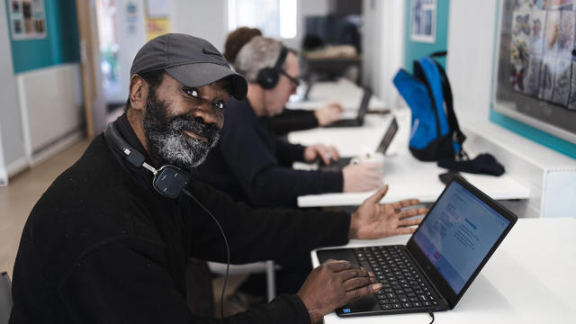 online digital sessions member on laptop smiling at the camera