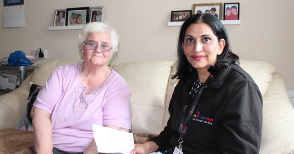 an elderly resident talking to the money saving expert on her sofa