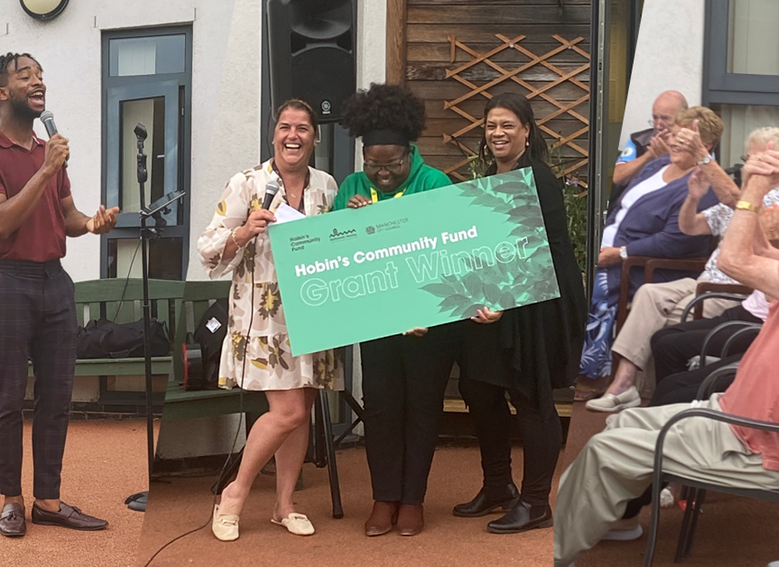 three hobin's winners holding a large cheque with people clapping