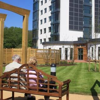 an older couple enjoying the sunshine on a bench at whitebeck court