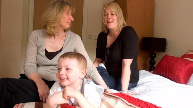 a grandmother, mother and son sat in the bedroom of a property in whitebeck court