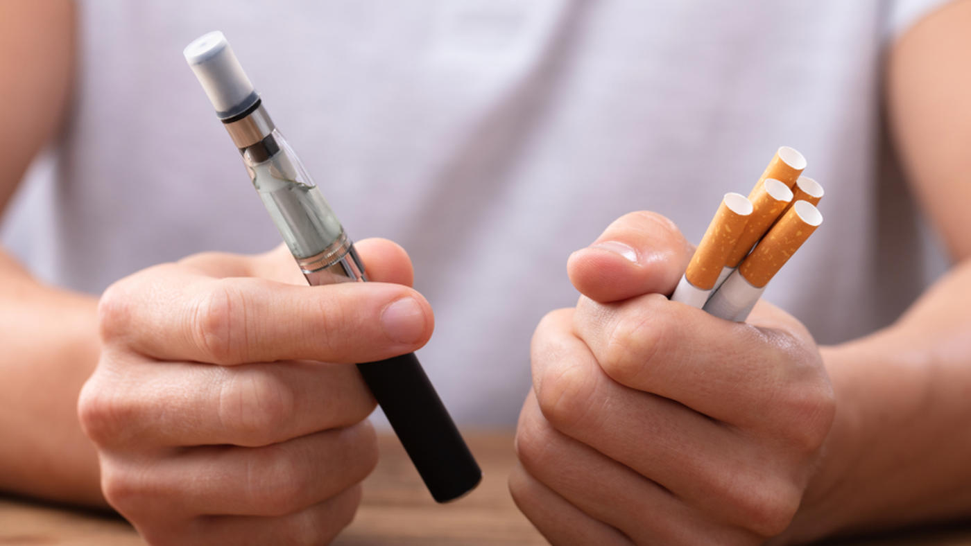 stop smoking scheme man holds vape and ciggies in hands