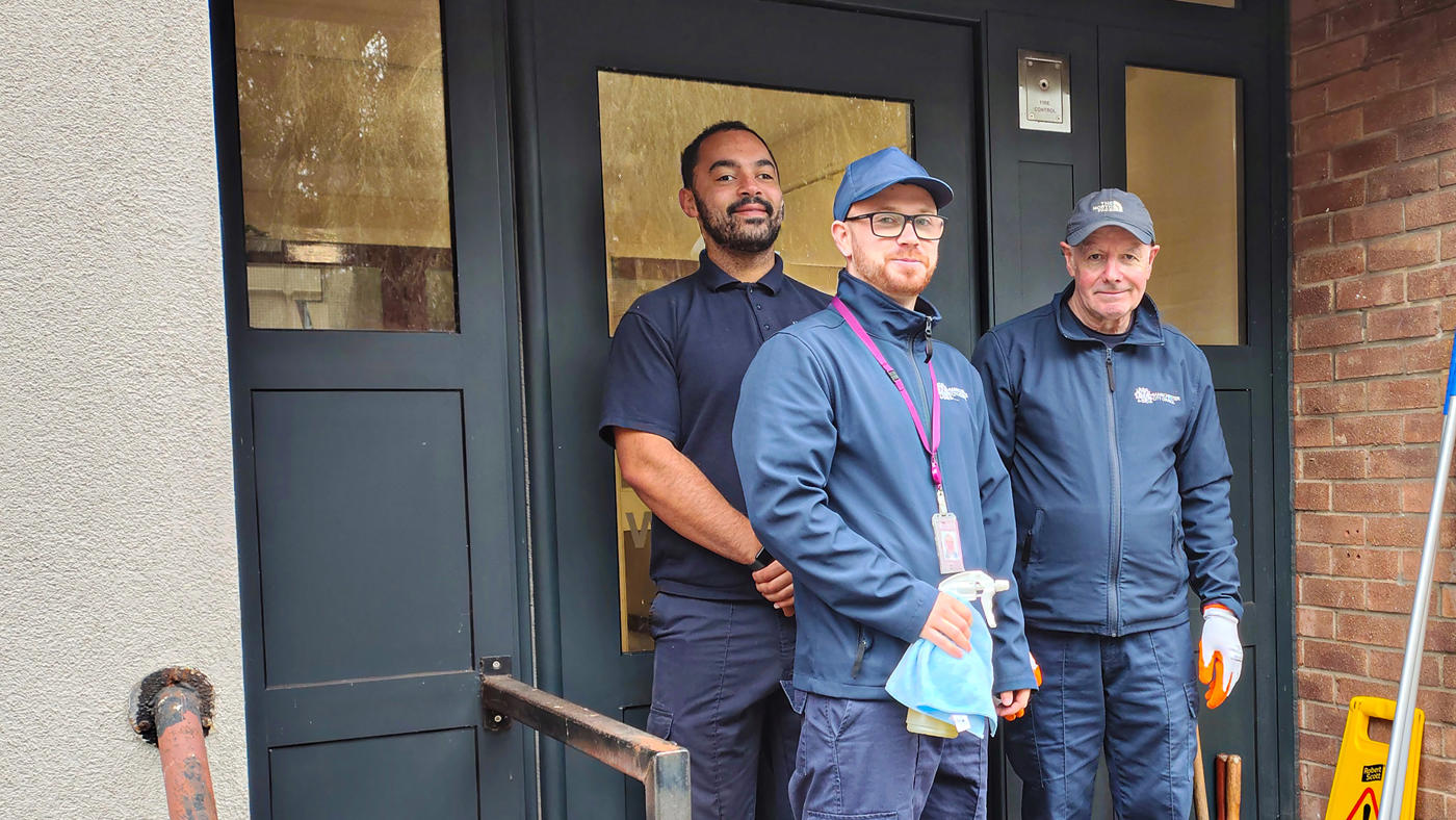 communal cleaning team stood on doorstep of a low rise block