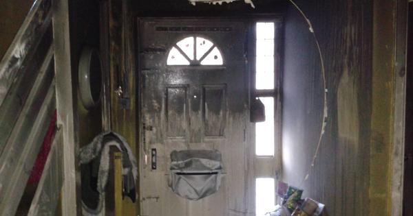 extensive fire damage of a home - showing the front door and landing