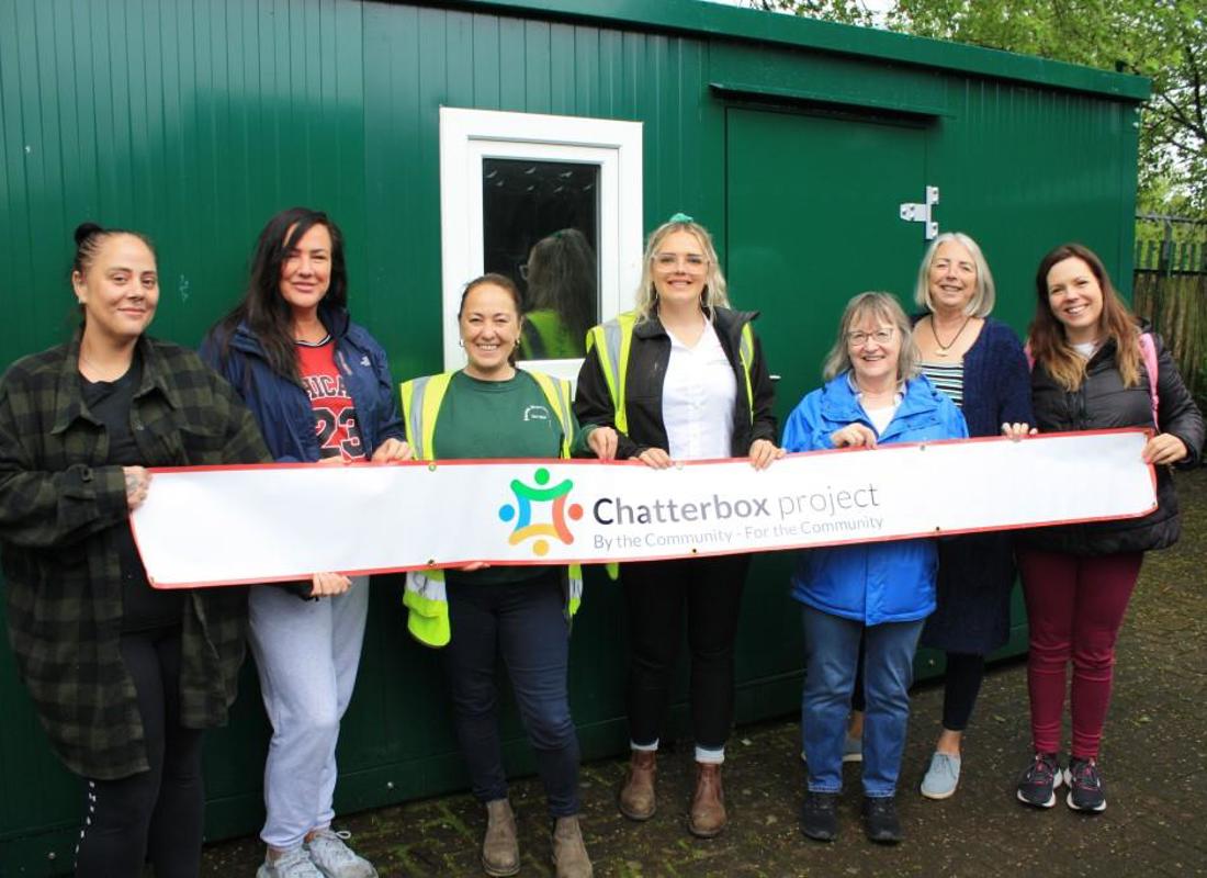 The Team At The Chatterbox Project In Front Of The Storage Unit With Some Of The Emanuel Whittaker Team Holding A Banner Saying Chatterbox