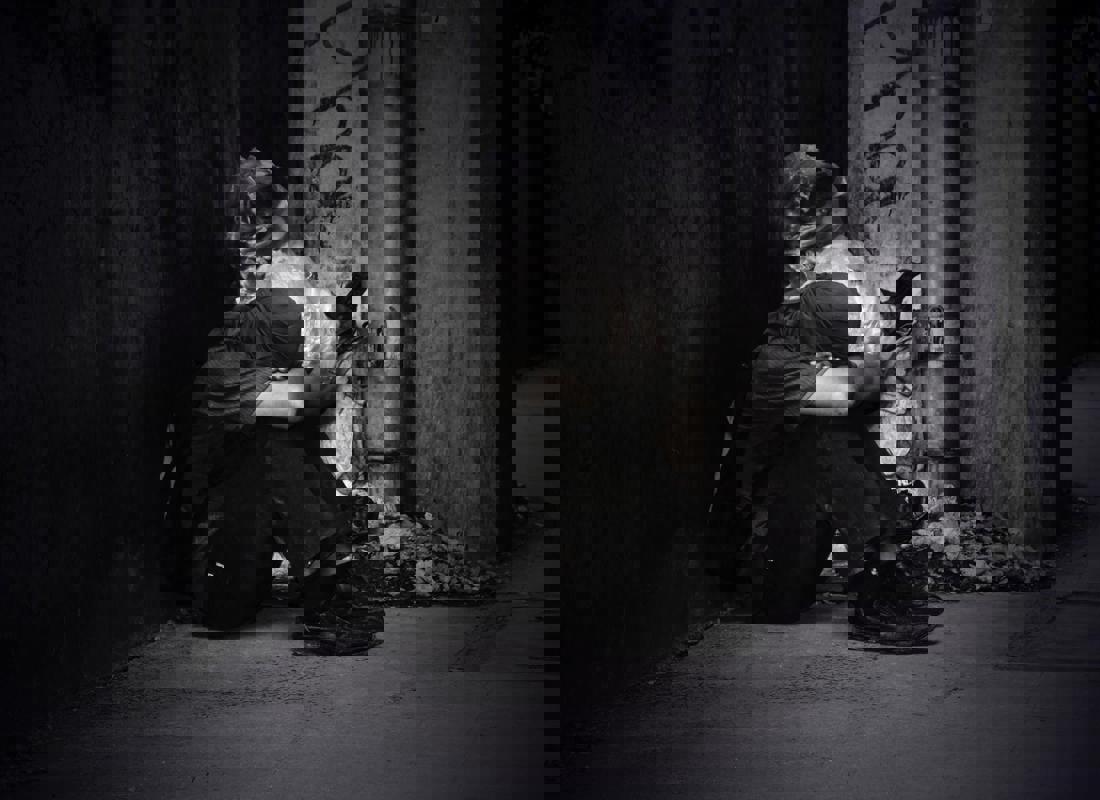 An Image Of A Homeless Man Sitting On The Street
