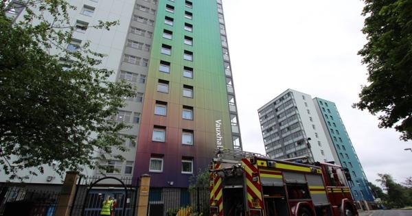 an image of vauxhall court high-rise apartments, from the car park. there's a fire engine parked outside.