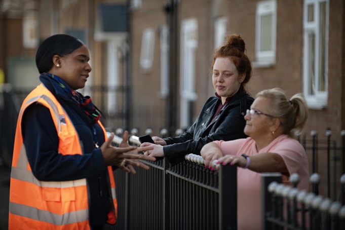 equans operative talking to two residents outside their home