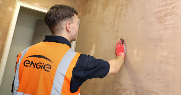 an engie engineer wiping down a newly plastered wall