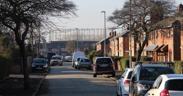 a street in newton heath with a gas works at the very end of the road