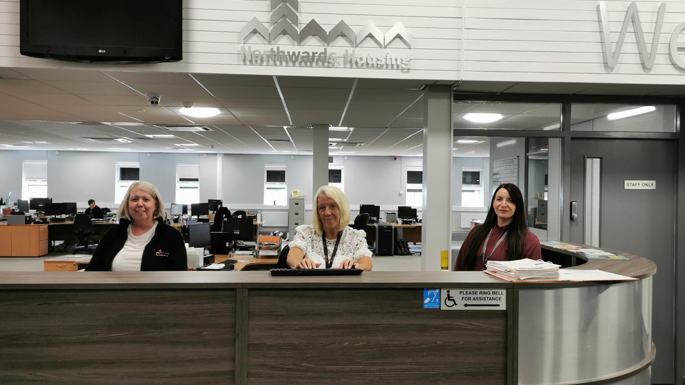 The Customer Service desk at White Moss Road, with three smiling members of staff