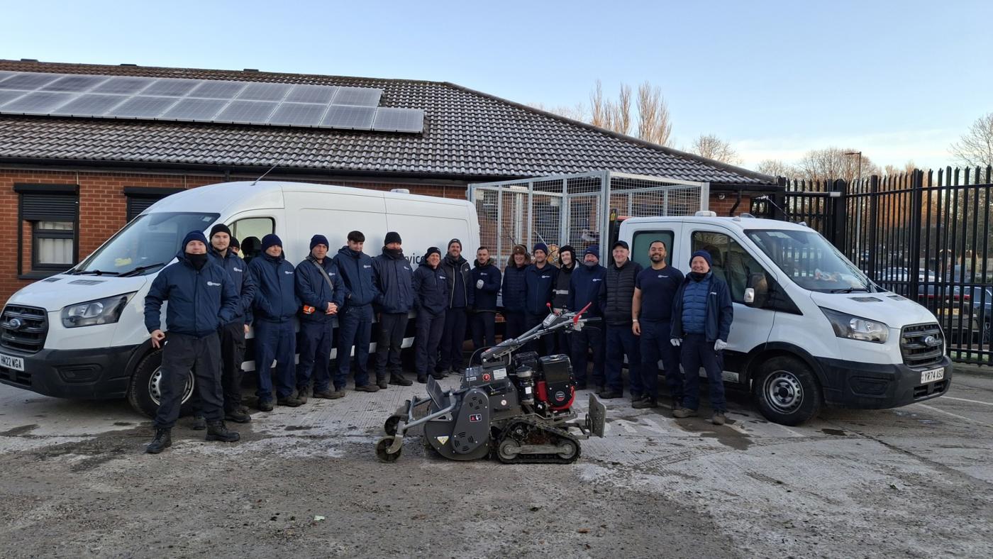 estate services new team posing in front of some machinery in the car park