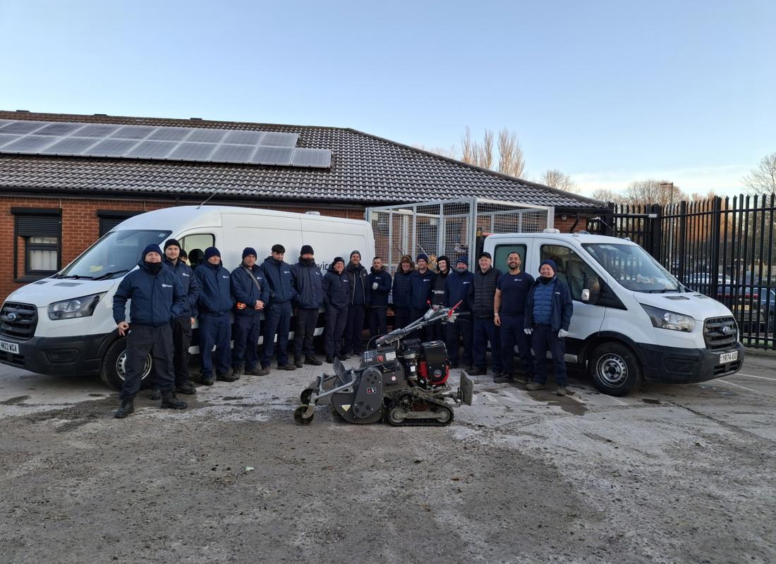 estate services new team posing in front of some machinery in the car park