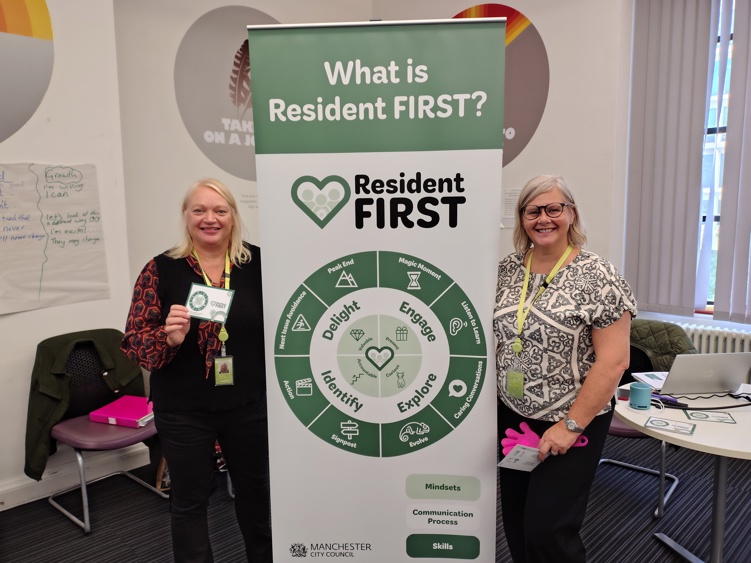 The Resident First training team posing with a 'What is Resident First?' pop-up banner