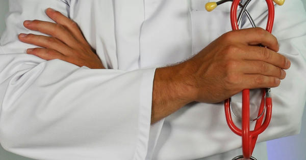 health and wellbeing a doctor holding a stethoscope with hands folded