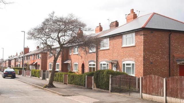 a row of semidetached houses on a street in north manchester