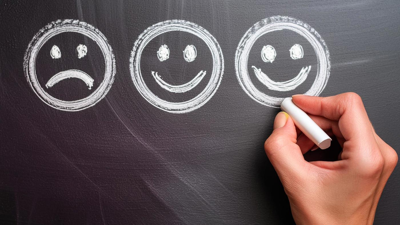 three ai generated smiley faces drawn on a blackboard by a hand holding chalk